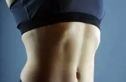 Close-up of a fit individual's torso, highlighting the benefits of HGH for bodybuilding and fitness.